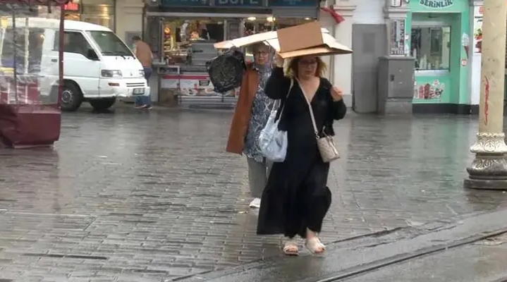 Taksim’de yağmura yakalananlar çanta ve kartonla korunmaya çalıştı